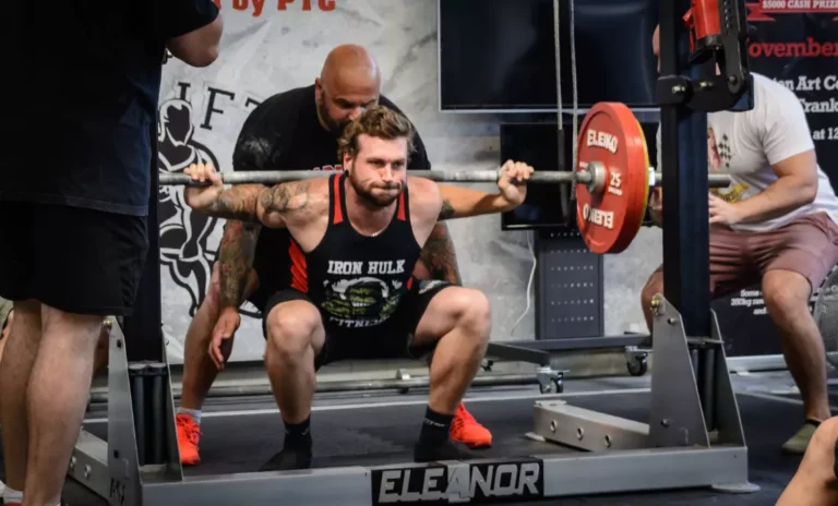 homme qui fait un squat en compétition de powerlifting